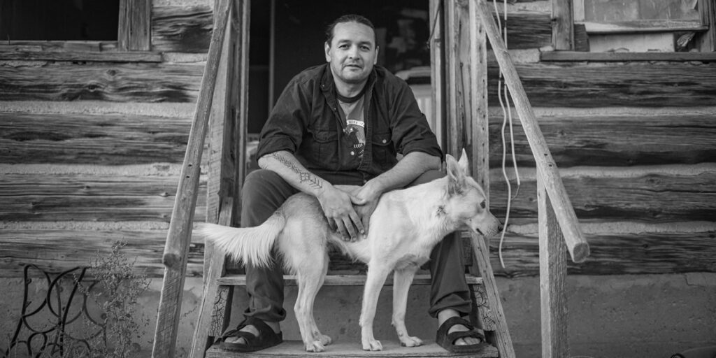 Jason Baldes, a member of the Eastern Shoshone Tribe, and his dog, Willi, in Morton, Wyoming, on the Wind River Indian Reservation. Photo by Russel Albert Daniels/High Country News